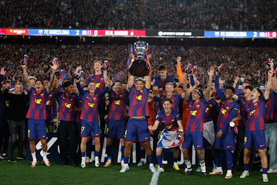 Watched by its grieving coach, Barcelona retains Spanish league title by beating rival Real Madrid