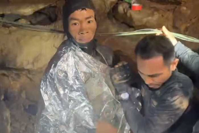 Rescuers evacuate the first of 5 villagers found trapped in a cave in Laos; 2 still missing